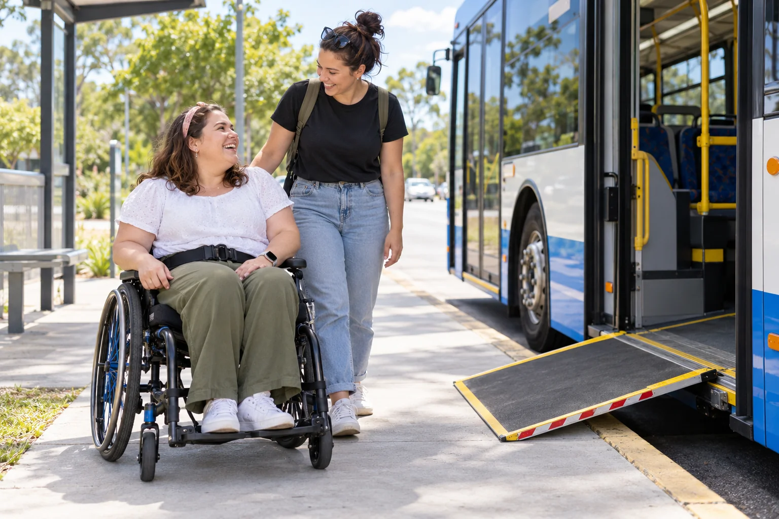 A woman using a wheelchair and a companion near an accessible bus